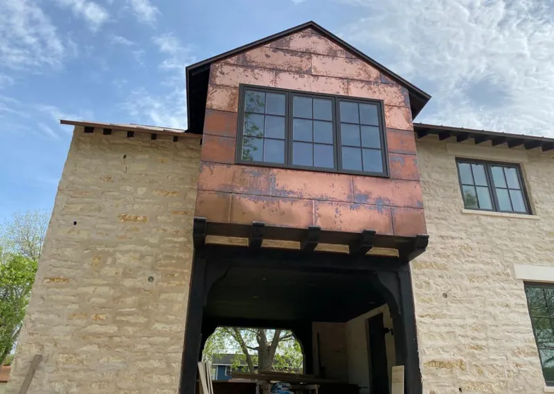 Copper metal panel facade on a stone building for Skylight Installation in Whiskey Creek